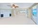 Spacious living room with built-in shelving, ceiling fan, and sliding doors to a private balcony with ocean view at 2545 S Atlantic Ave # 2107-2108, Daytona Beach Shores, FL 32118