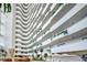 Grand lobby with plants and curved balconies in a modern high-rise residential building at 2545 S Atlantic Ave # 2107-2108, Daytona Beach Shores, FL 32118