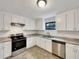 Modern kitchen with white cabinets, stainless steel appliances, and tile flooring at 1111 28Th Nw St, Winter Haven, FL 33881