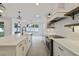 A clean white kitchen featuring an island with a sink and stainless steel appliances at 231 Severn Way # 36, Orlando, FL 32803