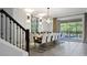 Bright dining room features a long table, modern chandelier, and glass sliding doors to the pool at 2726 Oxymoron Way, Kissimmee, FL 34746