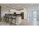 Modern kitchen features sleek white cabinetry, stainless appliances, gray backsplash, and eat-in island at 2726 Oxymoron Way, Kissimmee, FL 34746