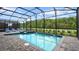 Sparkling screened-in pool with lounge chairs and adjacent spa for relaxation at 2726 Oxymoron Way, Kissimmee, FL 34746