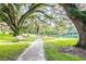 Brick pathway shaded by moss-draped oak trees at 213 Crown Oaks Way # 213, Longwood, FL 32779