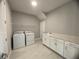 Bright laundry room with washer, dryer, and cabinets at 128 Lake Dr, Oviedo, FL 32765