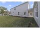 Backyard view of a two-story white house with a well-maintained lawn and landscaping at 2138 Forest Cir # 32, Orlando, FL 32803