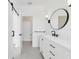 Bright bathroom featuring white cabinetry, black hardware, a round mirror, and modern fixtures at 2138 Forest Cir # 32, Orlando, FL 32803