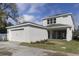 Exterior view of a two-story home with a two-car garage, manicured lawn, and modern design at 2138 Forest Cir # 32, Orlando, FL 32803