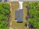 An aerial view of a home showing the driveway, roof, yard, and surrounding trees at 95 Malauka Place Trak, Ocklawaha, FL 32179