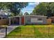 Inviting single-story home with a vibrant orange front door and covered carport at 618 S Lakeland Ave, Orlando, FL 32805