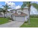 Two-story house with gray siding, brown roof, and a two-car garage, EV charger at 5205 Cape Hatteras Dr, Clermont, FL 34714