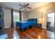 Bedroom features wood floors, a ceiling fan, a large window, a nightstand and a full length mirror at 7250 Westpointe Blvd # 1035, Orlando, FL 32835