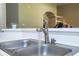Close-up of the stainless steel kitchen sink with modern faucet and water running, showcasing the functional space at 7250 Westpointe Blvd # 1035, Orlando, FL 32835