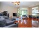 Bright living room with a ceiling fan, hardwood floors, and a balcony view at 7250 Westpointe Blvd # 1035, Orlando, FL 32835