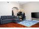 Open-concept living area featuring hardwood floors, a sectional sofa, and a workspace at 7250 Westpointe Blvd # 1035, Orlando, FL 32835