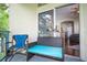 View of the cozy outdoor patio seating area with wicker furniture and vibrant turquoise cushions and the glass sliding doors at 7250 Westpointe Blvd # 1035, Orlando, FL 32835