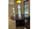 Well-lit dining area showcasing a round wooden table and views of the pool through the window at 2211 Rickover Pl, Winter Garden, FL 34787