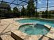 Relaxing screened-in pool and spa area overlooking a serene lake at 2211 Rickover Pl, Winter Garden, FL 34787