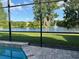 Screened-in pool offers captivating lake views with a fountain, enhancing the backyard oasis at 2211 Rickover Pl, Winter Garden, FL 34787