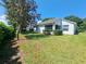 Spacious backyard with mature trees and grassy area at 3844 Eversholt St, Clermont, FL 34711