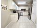 White kitchen with stainless steel appliances and tile floor at 3844 Eversholt St, Clermont, FL 34711