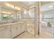 Bathroom with a large glass shower, dual vanities and tile floors at 737 Alcove Dr, Groveland, FL 34736