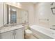 Well-lit bathroom with white cabinetry, granite counters, and a shower-tub combo at 737 Alcove Dr, Groveland, FL 34736