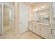 Bright bathroom with tile floor, dual sinks, and a shower with glass door at 737 Alcove Dr, Groveland, FL 34736