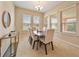 Bright dining room with large windows and modern table and chairs at 737 Alcove Dr, Groveland, FL 34736