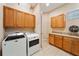 Laundry room with tile floors, storage cabinets, and modern washer and dryer at 737 Alcove Dr, Groveland, FL 34736