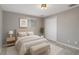 This bedroom features neutral tones, natural light, and a padded bench at the foot of the bed at 6003 Village Cir # Ge, Orlando, FL 32822
