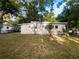 Exterior shot of the home's backyard, showcasing a private yard with green grass and mature trees at 122 Club Rd, Sanford, FL 32771
