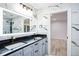 Modern bathroom featuring marble walls, a double vanity with black hardware, and an illuminated mirror at 1860 Via Contessa, Winter Park, FL 32789