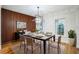 Elegant dining room featuring a modern light fixture, wood accent wall, and seating for six at 1860 Via Contessa, Winter Park, FL 32789