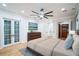 Spacious main bedroom featuring a large ceiling fan, wood floors, and a walk-in closet at 1860 Via Contessa, Winter Park, FL 32789