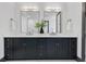 Bathroom featuring double sinks, black cabinets, quartz counters, modern fixtures and mirrors at 3480 Fairway Ln, Orlando, FL 32804