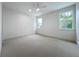 Bright bedroom with neutral carpet, ceiling fan, white walls and trim, and two windows at 3480 Fairway Ln, Orlando, FL 32804