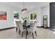 Cozy dining area featuring a contemporary chandelier, ample natural light, and a modern color palette at 3480 Fairway Ln, Orlando, FL 32804