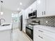 Modern kitchen featuring stainless steel appliances, quartz countertops, and stylish backsplash at 3480 Fairway Ln, Orlando, FL 32804