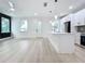 Open living space with a kitchen island that has pendant lights with many windows and a ceiling fan at 3480 Fairway Ln, Orlando, FL 32804