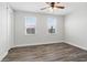 Bedroom with wood floors, ceiling fan, and two windows at 16829 Bolsena Dr, Montverde, FL 34756