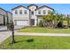 Two-story house with a white exterior, red tile roof, and landscaping at 16829 Bolsena Dr, Montverde, FL 34756