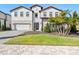 Two-story house with a white exterior, red tile roof, and landscaping at 16829 Bolsena Dr, Montverde, FL 34756