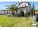 Landscaped yard with palm trees and a gray paved driveway at 16829 Bolsena Dr, Montverde, FL 34756