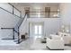 Two-story living room with a modern staircase and tiled floor at 16829 Bolsena Dr, Montverde, FL 34756