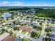 Expansive aerial view of a residential neighborhood with mature trees, a pond, and well-maintained lawns on a sunny day at 17843 Golden Leaf Ln, Orlando, FL 32820