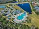 Aerial view of community pool, playground, tennis courts, pond with fountain, and clubhouse on a sunny day at 17843 Golden Leaf Ln, Orlando, FL 32820