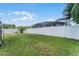 Large backyard with a white privacy fence, a grassy area, and a view of the neighboring home at 17843 Golden Leaf Ln, Orlando, FL 32820