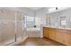 Bathroom featuring dual sinks, bathtub, and glass shower enclosure at 17843 Golden Leaf Ln, Orlando, FL 32820