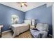 Bedroom with a ceiling fan, blue walls, and wood look flooring at 17843 Golden Leaf Ln, Orlando, FL 32820